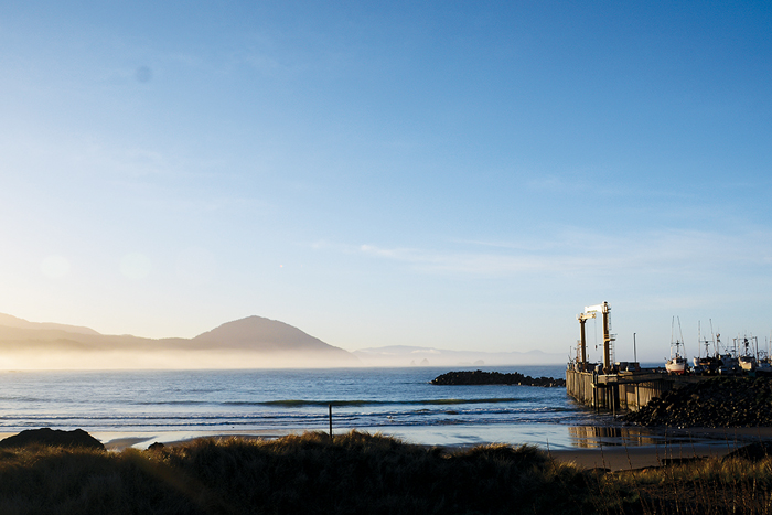 Commercial fishing vessel lining up for launch via gantry crane at sunrise at Port Orford, Oregon.