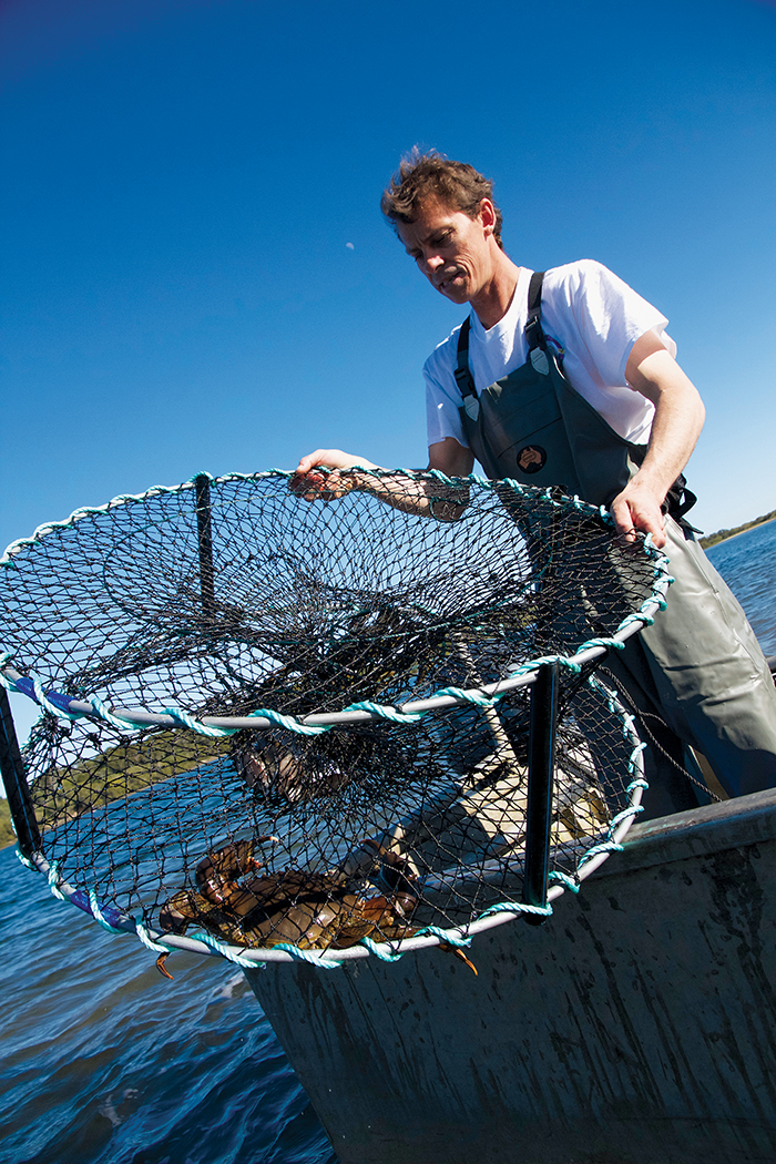 Photo of crab fisher Troy Billin putting out a crab pot