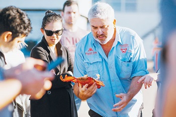 Photo of Jason Simpson and Thi Le discussing a spanner crab