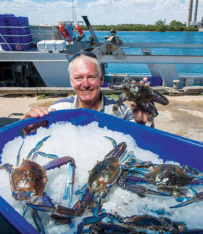 Photo of Dennis Holder with tub of blue crab on ice
