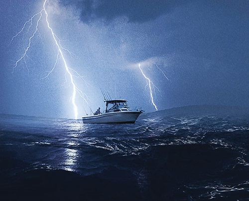 Photo of a boat with lightning on the ocean