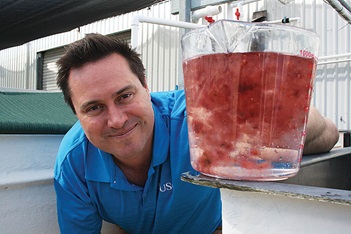Photo of Nick Paul holiding a jug of pink seaweed