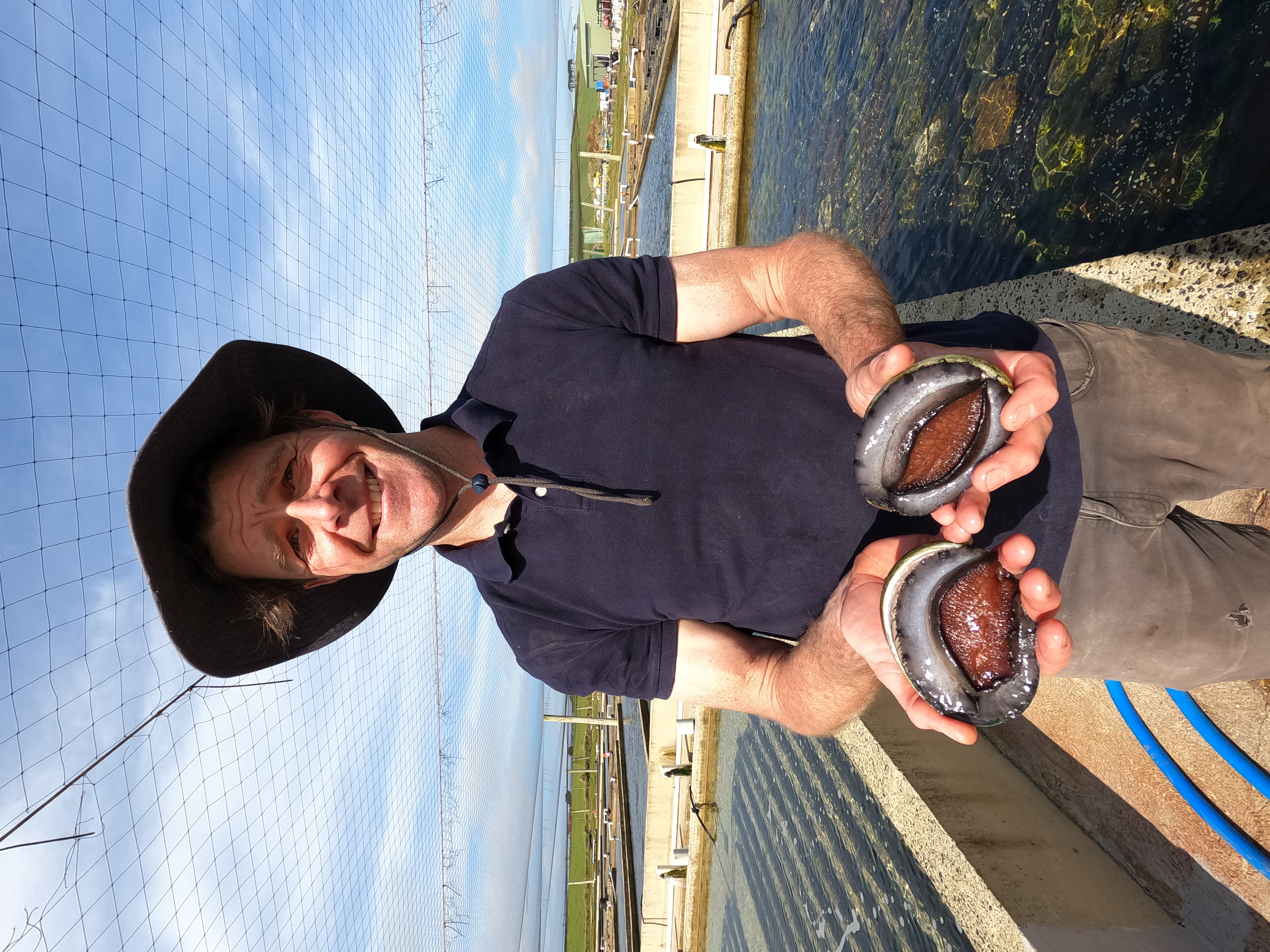 Three Friends Abalone Managing Director, Joel Gilby, with two market-ready farmed abalone. 