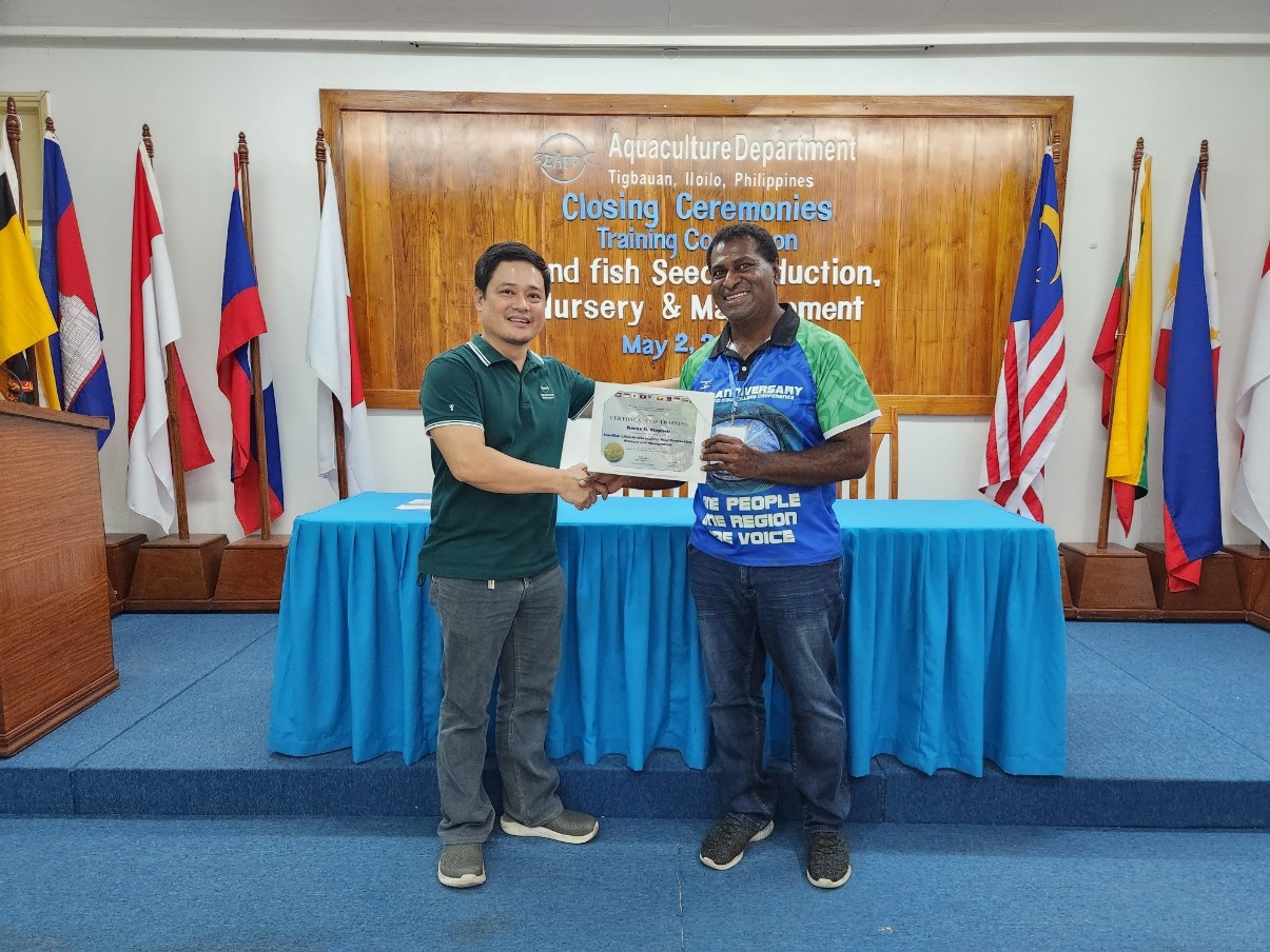 Rocky stephen standing with Phillipine sandfish course instructor, shaking hands and both holding Rocky's certificate
