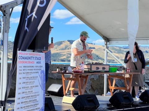 Photo of former River Cottage Australia Host, Paul West cooks up Octopus for the hungry crowds.